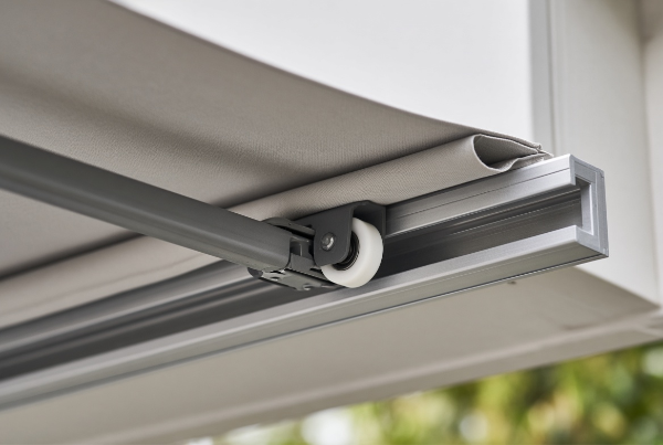 Nylon roller guiding an outdoor awning along its metal track